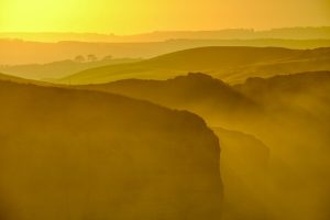 Image of rolling hills with yellow haze of sunlight